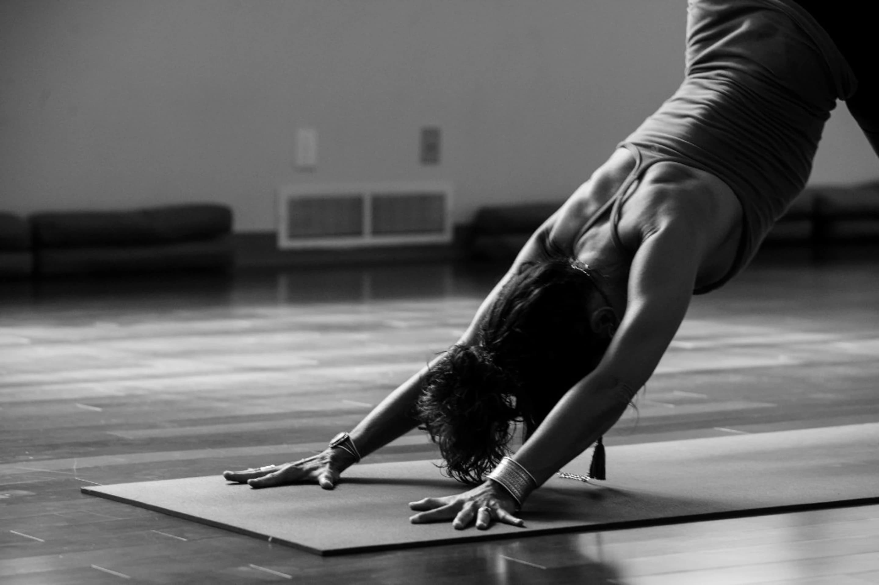 A woman holding a downward pose on a mat