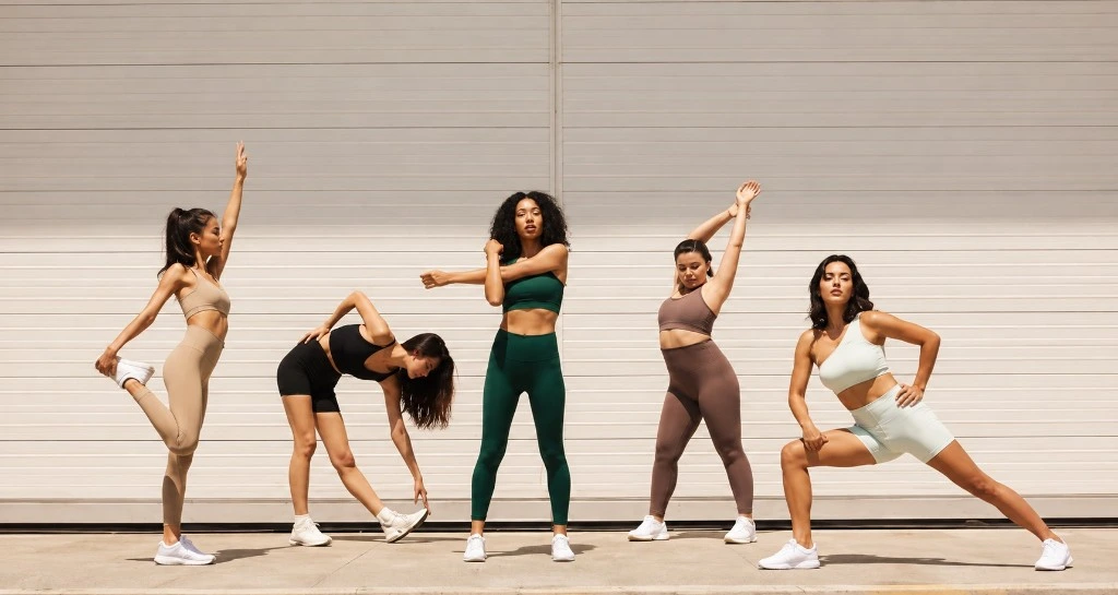 Five women holding standing stretches and lunges